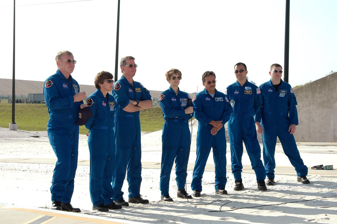 KENNEDY SPACE CENTER, FLA. - The STS-114 crew gathers for media questions at the slidewire basket landing area on Launch Pad 39B. Standing left to right are Mission Specialists Andrew Thomas, Wendy Lawrence and Stephen Robinson, Commander Eileen Collins, Mission Specialists Charles Camarda and Soichi Noguchi, and Pilot James Kelly. Noguchi is with the Japan Aerospace Exploration Agency. The TCDT is held at KSC prior to each Space Shuttle flight. It provides the crew of each mission an opportunity to participate in simulated countdown activities. The test ends with a mock launch countdown culminating in a simulated main engine cutoff. The crew also spends time undergoing emergency egress training exercises at the launch pad. STS-114 is designated the first Return to Flight mission, with a launch window extending from July 13 to July 31.