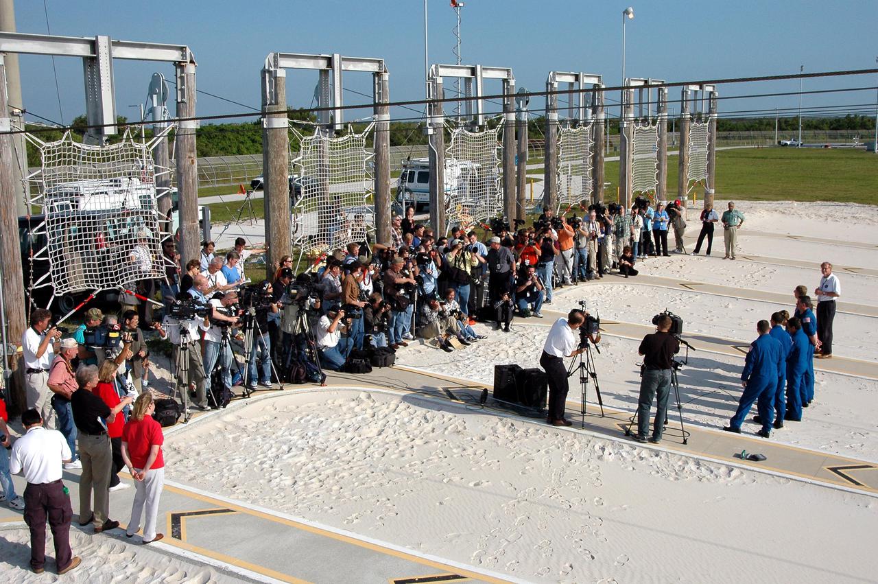 KENNEDY SPACE CENTER, FLA. - Dozens of media are gathered at the slidewire basket landing area on Launch Pad 39B to interview and hear comments from the STS-114 crew: Mission Specialists Andrew Thomas, Wendy Lawrence and Stephen Robinson, Commander Eileen Collins, Mission Specialists Charles Camarda and Soichi Noguchi, and Pilot James Kelly. Noguchi is with the Japan Aerospace Exploration Agency. The TCDT is held at KSC prior to each Space Shuttle flight. It provides the crew of each mission an opportunity to participate in simulated countdown activities. The test ends with a mock launch countdown culminating in a simulated main engine cutoff. The crew also spends time undergoing emergency egress training exercises at the launch pad. STS-114 is designated the first Return to Flight mission, with a launch window extending from July 13 to July 31.