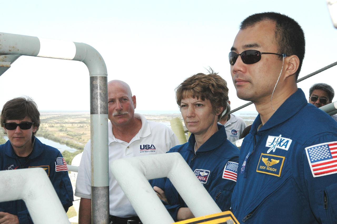 KENNEDY SPACE CENTER, FLA. - On the Fixed Service Structure at Launch Pad 39B, the STS-114 crew gets instructions on using the slidewire basket, emergency egress equipment from the pad. Crew members seen here are (from left) Mission Specialist Wendy Lawrence, Commander Eileen Collins and Mission Specialist Soichi Noguchi, who is with the Japan Aerospace Exploration Agency. The training is part of Terminal Countdown Demonstration Test activities. The TCDT is held at KSC prior to each Space Shuttle flight. It provides the crew of each mission an opportunity to participate in simulated countdown activities. The test ends with a mock launch countdown culminating in a simulated main engine cutoff. The crew also spends time undergoing emergency egress training exercises at the launch pad. STS-114 is designated the first Return to Flight mission, with a launch window extending from July 13 to July 31.