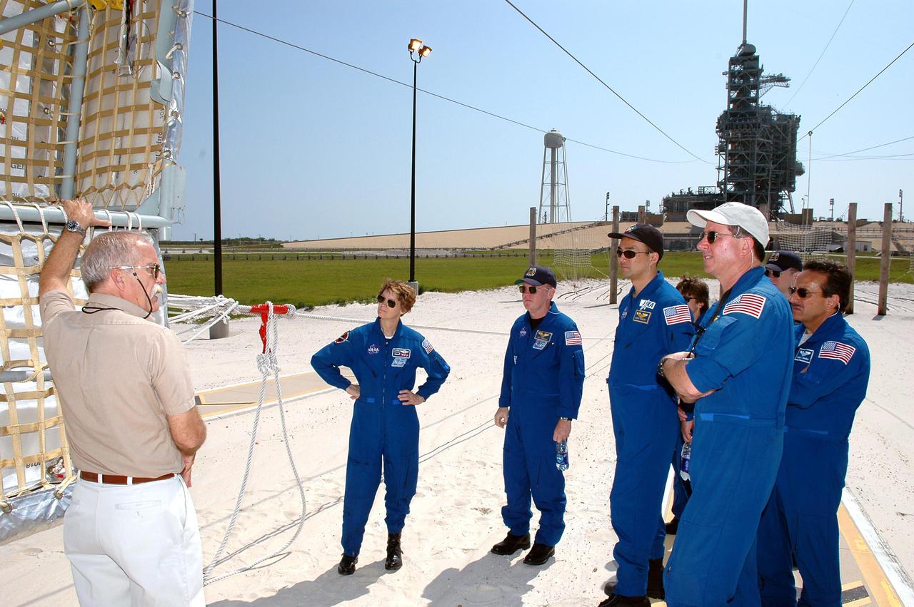 KENNEDY SPACE CENTER, FLA. - The STS-114 crew learn about exiting the slidewire basket at this landing area should they need to leave the Space Shuttle in an emergency situation while on the pad. Crew members seen here are (from left) Commander Eileen Collins and Mission Specialists Andrew Thomas, Soichi Noguchi, Wendy Lawrence, Stephen Robinson and Charles Camarda. Not pictured is Pilot James Kelly. Noguchi is with the Japan Aerospace Exploration Agency. The training is part of Terminal Countdown Demonstration Test activities. The TCDT is held at KSC prior to each Space Shuttle flight. It provides the crew of each mission an opportunity to participate in simulated countdown activities. The test ends with a mock launch countdown culminating in a simulated main engine cutoff. The crew also spends time undergoing emergency egress training exercises at the launch pad. STS-114 is designated the first Return to Flight mission, with a launch window extending from July 13 to July 31.