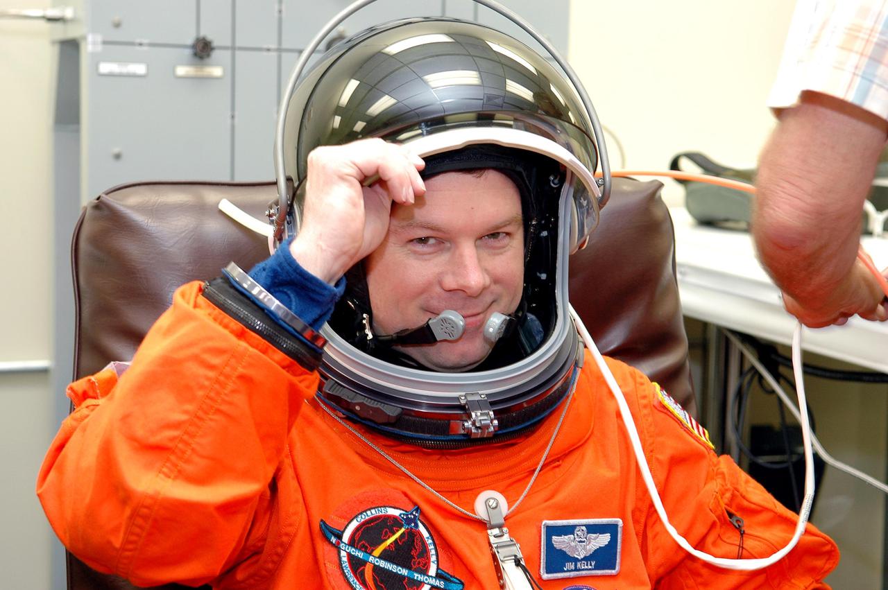 KENNEDY SPACE CENTER, FLA. -STS-114 Pilot James Kelly suits up in the Operations and Checkout Building for the trip to Launch Pad 39B for a mock launch countdown culminating in a simulated main engine cutoff. The dress rehearsal is part of Terminal Countdown Demonstration Test (TCDT) activities held prior to each Space Shuttle flight. It provides the crew of each mission an opportunity to participate in various simulated countdown activities, including equipment familiarization and emergency egress training. STS-114 is the first Return to Flight mission to the International Space Station. The launch window extends July 13 through July 31.