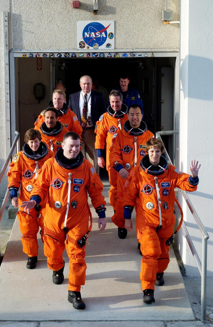 KENNEDY SPACE CENTER, FLA. - STS-114 Commander Eileen Collins leads the way as the next Space Shuttle crew does a practice walkout from the Operations and Checkout Building en route to Launch Pad 39B for a mock launch countdown culminating in a simulated main engine cutoff. In the left row, from front, are Pilot James Kelly and Mission Specialists Wendy Lawrence, Charles Camarda, and Andrew Thomas. In the right row, from front, are Collins and Mission Specialists Soichi Noguchi and Stephen Robinson. Noguchi is with the Japan Aerospace Exploration Agency. The dress rehearsal is part of Terminal Countdown Demonstration Test (TCDT) activities held prior to each Space Shuttle flight. It provides the crew of each mission an opportunity to participate in various simulated countdown activities, including equipment familiarization and emergency egress training. STS-114 is the first Return to Flight mission to the International Space Station. The launch window extends July 13 through July 31.