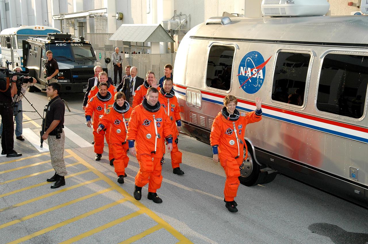 KENNEDY SPACE CENTER, FLA. - Outside the Operations and Checkout Building, STS-114 Commander Eileen Collins leads the way to the Astrovan that will transport the crew to Launch Pad 39B for a mock launch countdown culminating in a simulated main engine cutoff. In the left row, from front, are Pilot James Kelly and Mission Specialists Wendy Lawrence, Charles Camarda, and Andrew Thomas. In the right row, from front, are Collins and Mission Specialists Soichi Noguchi and Stephen Robinson. Noguchi is with the Japan Aerospace Exploration Agency. The dress rehearsal is part of Terminal Countdown Demonstration Test (TCDT) activities held prior to each Space Shuttle flight. It provides the crew of each mission an opportunity to participate in various simulated countdown activities, including equipment familiarization and emergency egress training. STS-114 is the first Return to Flight mission to the International Space Station. The launch window extends July 13 through July 31.