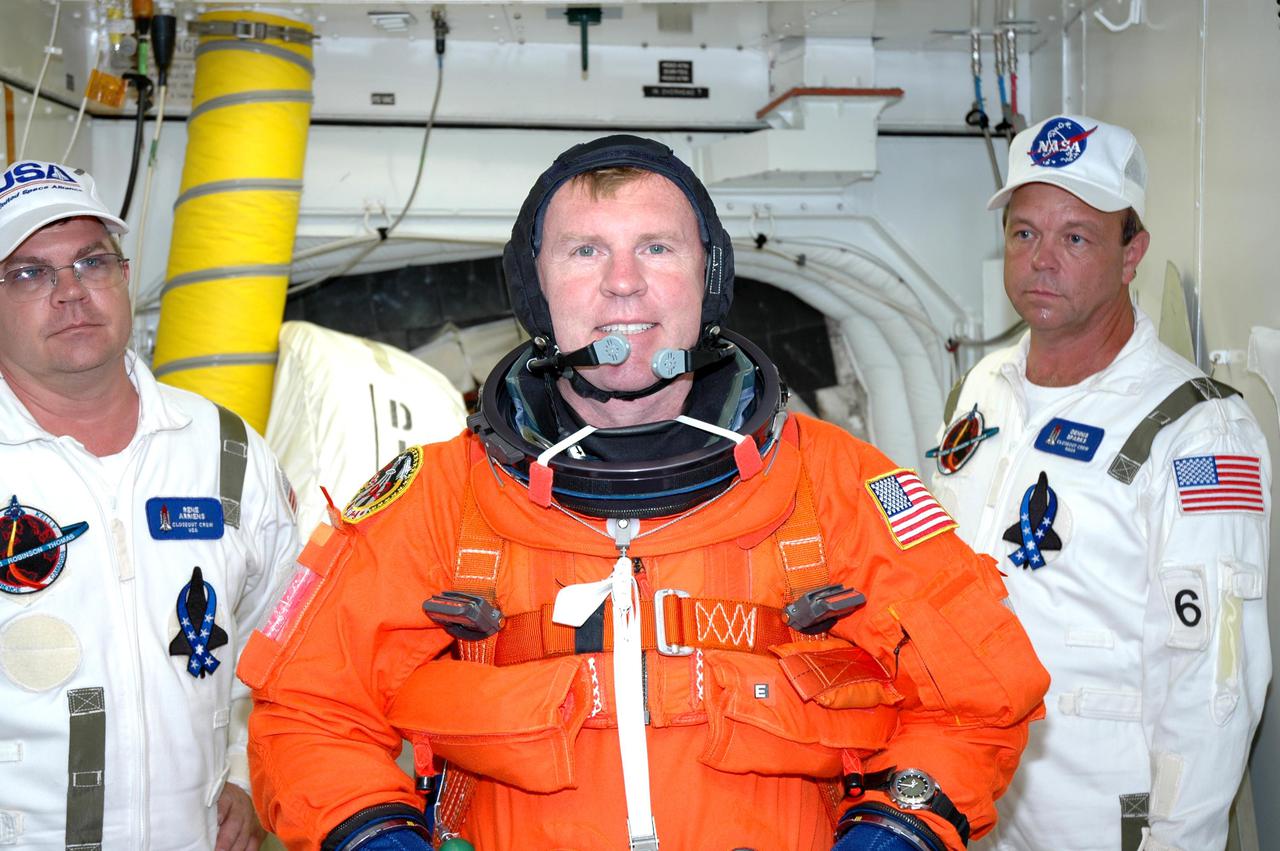 KENNEDY SPACE CENTER, FLA. - With the Closeout Crew looking on in the White Room on Launch Pad 39B, STS-114 Mission Specialist Andrew Thomas has donned his launch suit before entering Space Shuttle Discovery. The crew is taking part in a full dress rehearsal for launch, including countdown and culminating in main engine cutoff. The rehearsal is the final part of Terminal Countdown Demonstration Test (TCDT) activities that the crew has been involved in for three days. TCDT provides the crew of each mission an opportunity to participate in various simulated countdown activities, including equipment familiarization and emergency egress training. STS-114 is the first Return to Flight mission to the International Space Station. The launch window extends July 13 through July 31.