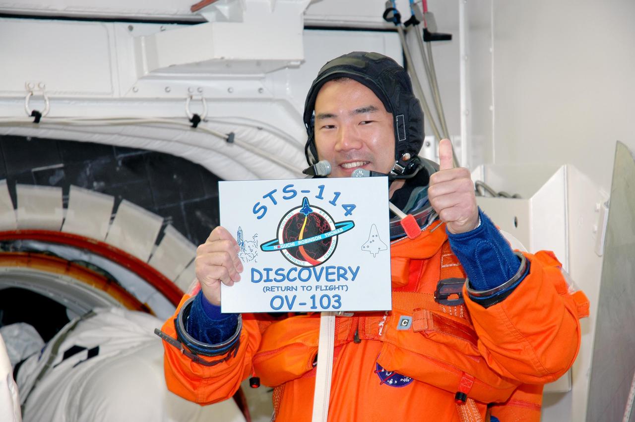 KENNEDY SPACE CENTER, FLA. - STS-114 Mission Specialist Soichi Noguchi holds the mission patch that will be attached to Space Shuttle Discovery for flight. Noguchi is with the Japan Aerospace Exploration Agency. The crew is taking part in a full dress rehearsal for launch, including countdown and culminating in main engine cutoff. The rehearsal is the final part of Terminal Countdown Demonstration Test (TCDT) activities that the crew has been involved in for three days. TCDT provides the crew of each mission an opportunity to participate in various simulated countdown activities, including equipment familiarization and emergency egress training. STS-114 is the first Return to Flight mission to the International Space Station. The launch window extends July 13 through July 31.