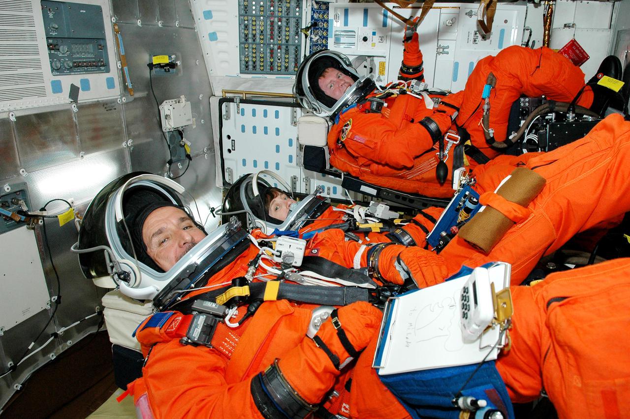 KENNEDY SPACE CENTER, FLA. - STS-114 crew members take part in a mock countdown as pre-launch training included in Terminal Countdown Demonstration Test (TCDT) activities. Seen here in their seats in the mid-deck of Space Shuttle Discovery are (left to right), Mission Specialists Charles Camarda, Wendy Lawrence and Andrew Thomas. TCDT provides the crew of each mission an opportunity to participate in various simulated countdown activities, including equipment familiarization and emergency egress training. STS-114 is the first Return to Flight mission to the International Space Station. The launch window extends July 13 through July 31.