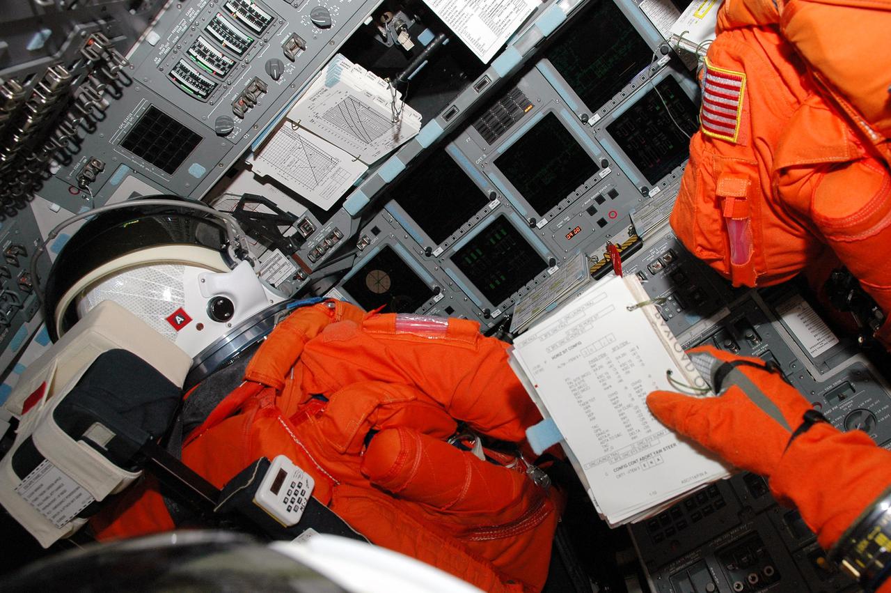 KENNEDY SPACE CENTER, FLA. - STS-114 crew members take part in a mock countdown as pre-launch training included in Terminal Countdown Demonstration Test (TCDT) activities. Seen here in their seats on the flight deck are Commander Eileen Collins (left) and Pilot James Kelly (right). TCDT provides the crew of each mission an opportunity to participate in various simulated countdown activities, including equipment familiarization and emergency egress training. STS-114 is the first Return to Flight mission to the International Space Station. The launch window extends July 13 through July 31.