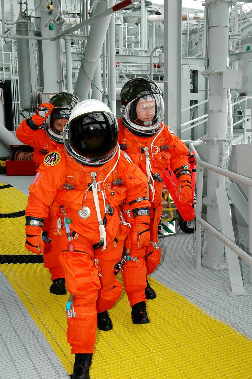 KENNEDY SPACE CENTER, FLA. - Following the mock countdown on Launch Pad 39B, STS-114 Mission Specialists Wendy Lawrence (front), Charles Camarda and Andrew Thomas make a speedy exit on the 195-foot level of the Fixed Service Structure. Emergency egress is part of the pre-launch training included in Terminal Countdown Demonstration Test (TCDT) activities. TCDT provides the crew of each mission an opportunity to participate in various simulated countdown activities, including equipment familiarization and emergency egress training. STS-114 is the first Return to Flight mission to the International Space Station. The launch window extends July 13 through July 31.