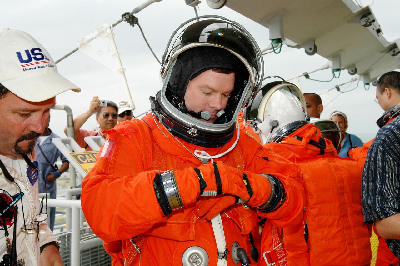 KENNEDY SPACE CENTER, FLA. -  Following the mock countdown on Launch Pad 39B, STS-114 Pilot James Kelly adjusts his glove before climbing into a slidewire basket used for emergency egress from the Fixed Service Structure at the pad.  This is part of the pre-launch training included in Terminal Countdown Demonstration Test (TCDT) activities.  TCDT provides the crew of each mission an opportunity to participate in various simulated countdown activities, including equipment familiarization and emergency egress training. STS-114 is the first Return to Flight mission to the International Space Station. The launch window extends July 13 through July 31.