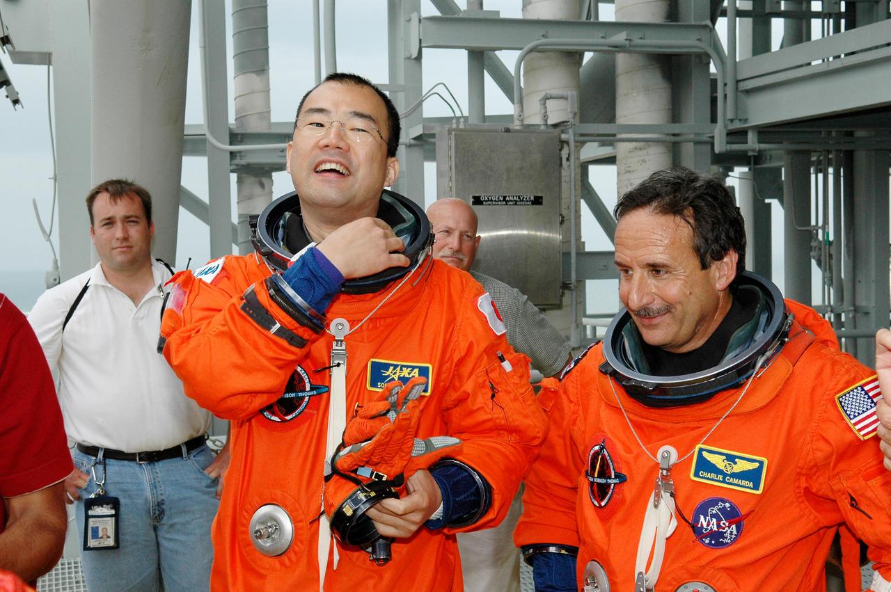 KENNEDY SPACE CENTER, FLA. -  Following the mock countdown on Launch Pad 39B, STS-114 Mission Specialists Soichi Noguchi (left) and Charles Camarda wait for their turn in the slidewire basket used for emergency egress from the Fixed Service Structure at the pad.  This is part of the pre-launch training included in Terminal Countdown Demonstration Test (TCDT) activities.  TCDT provides the crew of each mission an opportunity to participate in various simulated countdown activities, including equipment familiarization and emergency egress training. STS-114 is the first Return to Flight mission to the International Space Station. The launch window extends July 13 through July 31.