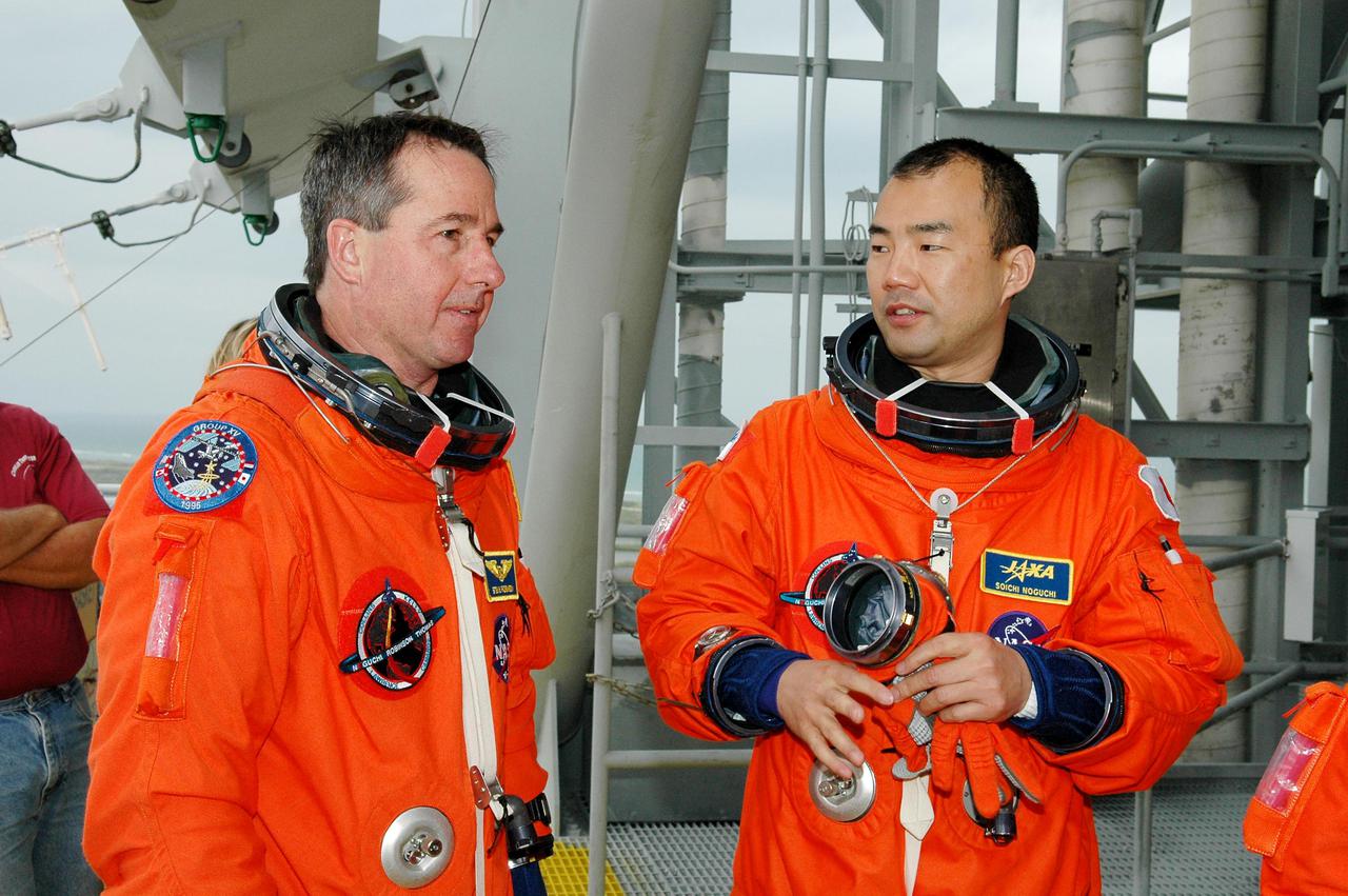 KENNEDY SPACE CENTER, FLA. -  Following the mock countdown on Launch Pad 39B, STS-114 Mission Specialist Stephen Robinson (left) and Soichi Noguchi talk at the slidewire basket area used for emergency egress from the Fixed Service Structure at the pad.  This is part of the pre-launch training included in Terminal Countdown Demonstration Test (TCDT) activities.   TCDT provides the crew of each mission an opportunity to participate in various simulated countdown activities, including equipment familiarization and emergency egress training. STS-114 is the first Return to Flight mission to the International Space Station. The launch window extends July 13 through July 31.
