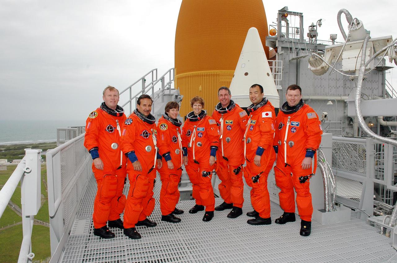 KENNEDY SPACE CENTER, FLA. - Following the mock countdown and emergency egress practice from the Fixed Service Structure on Launch Pad 39B, STS-114 crew members come together for a group photo on the 225-foot level. Pictured, from left, are Mission Specialists Andrew Thomas, Charles Camarda and Wendy Lawrence, Commander Eileen Collins, Mission Specialists Stephen Robinson and Soichi Noguchi, and Pilot James. Kelly. This culminates the pre-launch training known as Terminal Countdown Demonstration Test (TCDT) activities. TCDT provides the crew of each mission an opportunity to participate in various simulated countdown activities, including equipment familiarization and emergency egress training. STS-114 is the first Return to Flight mission to the International Space Station. The launch window extends July 13 through July 31.