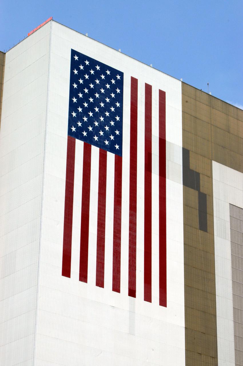 KENNEDY SPACE CENTER, FLA. -   The American flag on the side of the Vehicle Assembly Building at NASA’s Kennedy Space Center is newly painted.  The flag was damaged in the hurricanes of 2004 that assaulted the east coast of Florida.  Winds pulled a number of panels from the side of the 525-foot-high building.  The flag is 209 feet by 110 feet. Each star is more than six feet in diameter and each stripe is nine feet wide.  The flag sits more than 450 feet above the ground.