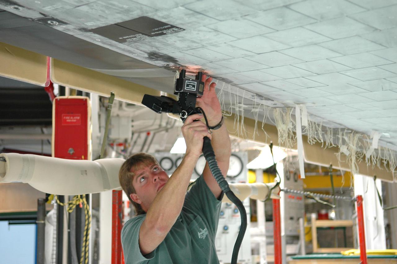 KENNEDY SPACE CENTER, FLA. - In Orbiter Processing Facility bay 1 at NASA’s Kennedy Space Center, United Space Alliance technician Greg Goforth uses a laser tool to take step and gap measurements on Thermal Protection System tiles on the underside of orbiter Atlantis. Other processing continues on Atlantis for its mission, designated STS-121, to the International Space Station. The launch planning window is Sept. 9 - 24.