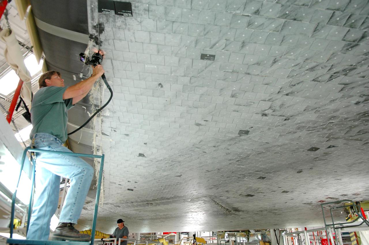 KENNEDY SPACE CENTER, FLA. - In Orbiter Processing Facility bay 1 at NASA’s Kennedy Space Center, United Space Alliance technician Greg Goforth uses a laser tool to take step and gap measurements on Thermal Protection System tiles on the underside of orbiter Atlantis. Other processing continues on Atlantis for its mission, designated STS-121, to the International Space Station. The launch planning window is Sept. 9 - 24.