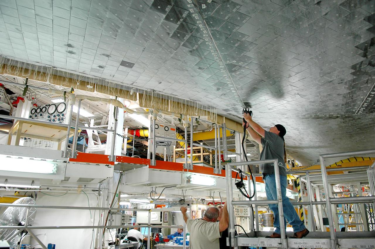KENNEDY SPACE CENTER, FLA. - In Orbiter Processing Facility bay 1 at NASA’s Kennedy Space Center, United Space Alliance technician Butch Lato uses a laser tool to take step and gap measurements on Thermal Protection System tiles on the underside of orbiter Atlantis. Other processing continues on Atlantis for its mission, designated STS-121, to the International Space Station. The launch planning window is Sept. 9 - 24.
