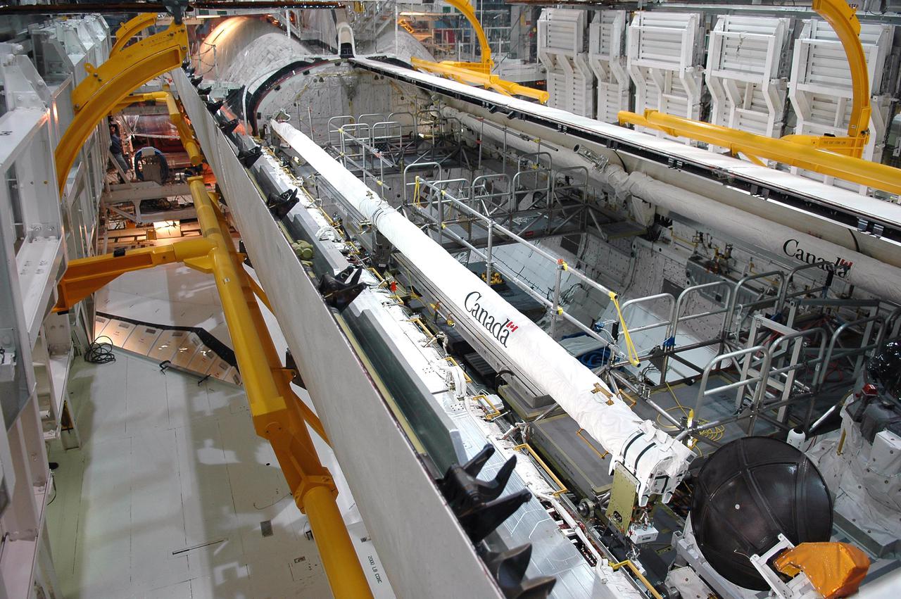 KENNEDY SPACE CENTER, FLA. - In Orbiter Processing Facility bay 1 at NASA’s Kennedy Space Center, Atlantis’ payload bay doors are open. The Remote Manipulator System, or Shuttle arm, is seen on the port side (top) and Orbiter Boom Sensor System (OBSS) is seen on the starboard side (lower) of the payload bay. The 50-foot-long OBSS attaches to the Shuttle arm and is one of the new safety measures for Return to Flight. It equips the orbiter with cameras and laser systems to inspect the Shuttle’s Thermal Protection System while in space. Mission STS-121 is targeted for launch in September. Once Atlantis' bay doors are open again, further work will be done in the bay.