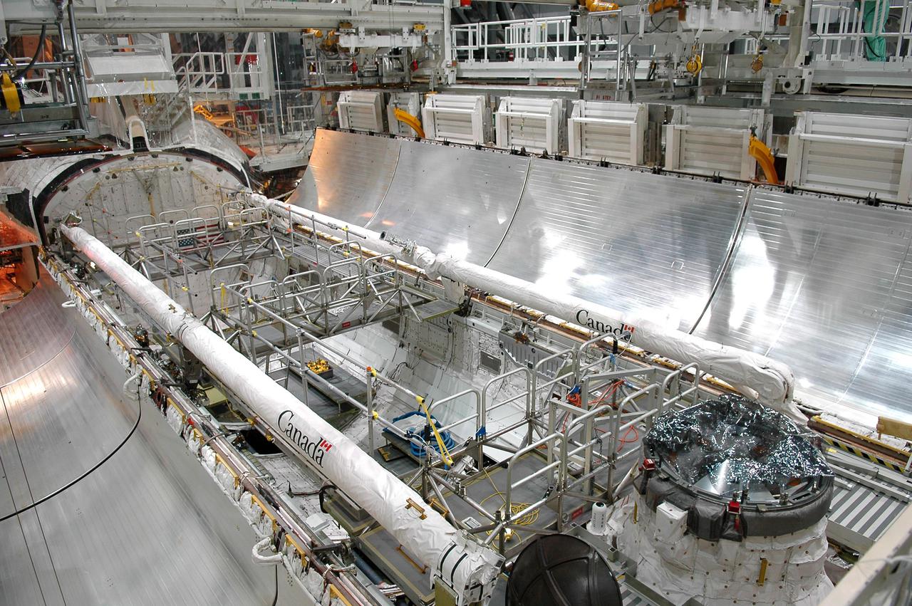 KENNEDY SPACE CENTER, FLA. - In Orbiter Processing Facility bay 1 at NASA’s Kennedy Space Center, Atlantis’ payload bay doors are fully open.  The Remote Manipulator System, or Shuttle arm, is seen on the port side (top) and Orbiter Boom Sensor System (OBSS) is seen on the starboard side (lower) of the payload bay.  The 50-foot-long OBSS attaches to the Shuttle arm and is one of the new safety measures for Return to Flight.  It equips the orbiter with cameras and laser systems to inspect the Shuttle’s Thermal Protection System while in space.  Mission STS-121 is targeted for launch in September.  Once Atlantis' bay doors are open again, further work will be done in the bay.