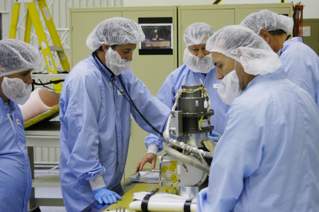 KENNEDY SPACE CENTER, FLA. - In the Payload Hazardous Servicing Facility at NASA’s Kennedy Space Center, engineers prepare to install the gimbal on the Mars Reconnaissance Orbiter (MRO) solar panel. A gimbal is an appliance that allows an object to remain horizontal even as its support tips. In the PHSF, the spacecraft will undergo multiple mechanical assembly operations and electrical tests to verify its readiness for launch. A major deployment test will check out the spacecraft’s large solar arrays. The MRO was built by Lockheed Martin for NASA’s Jet Propulsion Laboratory in California. It is the next major step in Mars exploration and scheduled for launch from Cape Canaveral Air Force Station in a window opening Aug. 10. The MRO is an important next step in fulfilling NASA’s vision of space exploration and ultimately sending human explorers to Mars and beyond.
