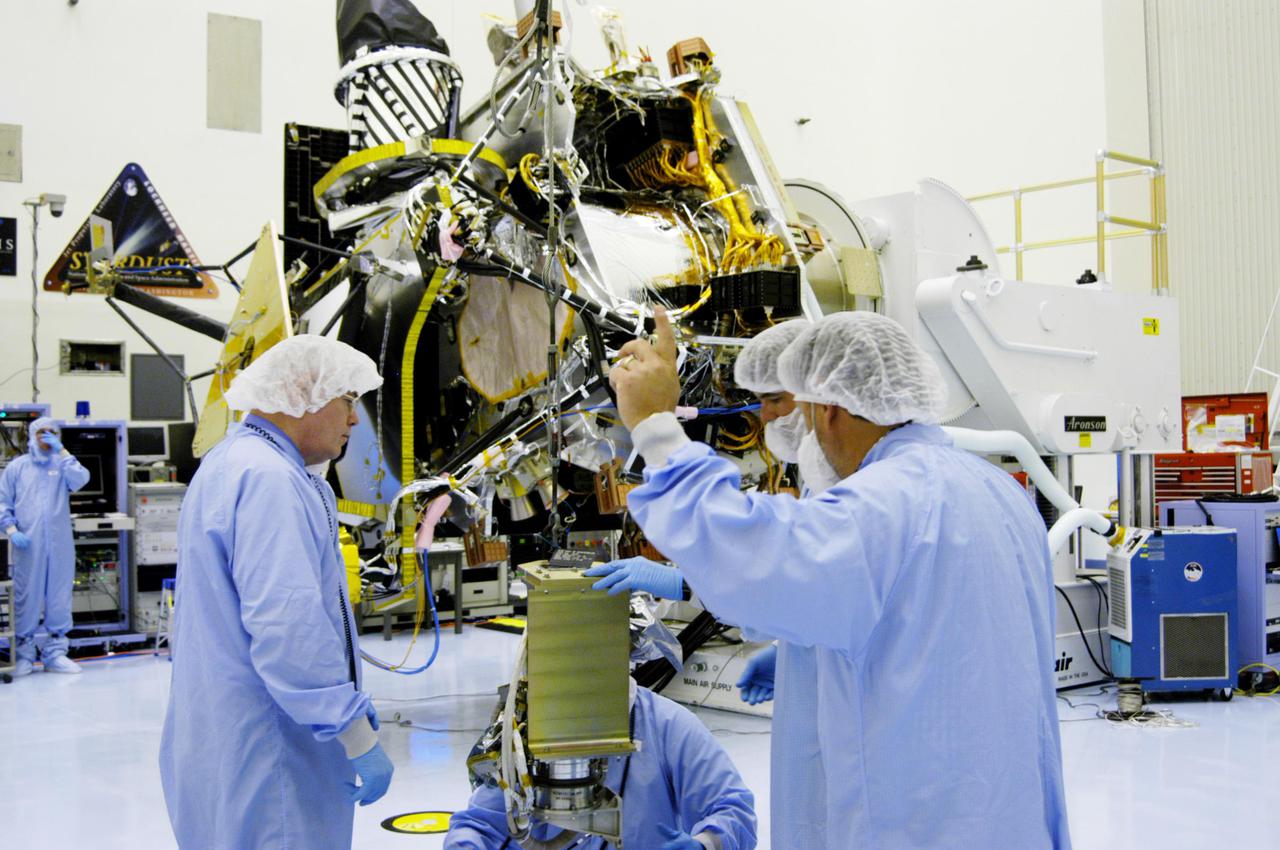 KENNEDY SPACE CENTER, FLA. - In the Payload Hazardous Servicing Facility at NASA’s Kennedy Space Center, engineers prepare to install the gimbal on the Mars Reconnaissance Orbiter (MRO) solar panel. A gimbal is an appliance that allows an object to remain horizontal even as its support tips. In the background is the orbiter. In the PHSF, the spacecraft will undergo multiple mechanical assembly operations and electrical tests to verify its readiness for launch. A major deployment test will check out the spacecraft’s large solar arrays. The MRO was built by Lockheed Martin for NASA’s Jet Propulsion Laboratory in California. It is the next major step in Mars exploration and scheduled for launch from Cape Canaveral Air Force Station in a window opening Aug. 10. The MRO is an important next step in fulfilling NASA’s vision of space exploration and ultimately sending human explorers to Mars and beyond.