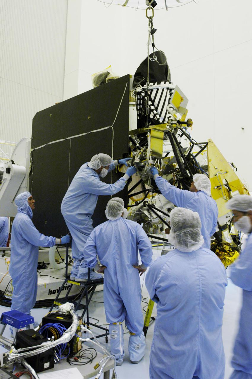 KENNEDY SPACE CENTER, FLA. - In the Payload Hazardous Servicing Facility at NASA’s Kennedy Space Center, engineers begin installing the gimbal on the Mars Reconnaissance Orbiter (MRO) solar panel. A gimbal is an appliance that allows an object to remain horizontal even as its support tips. In the PHSF, the spacecraft will undergo multiple mechanical assembly operations and electrical tests to verify its readiness for launch. A major deployment test will check out the spacecraft’s large solar arrays. The MRO was built by Lockheed Martin for NASA’s Jet Propulsion Laboratory in California. It is the next major step in Mars exploration and scheduled for launch from Cape Canaveral Air Force Station in a window opening Aug. 10. The MRO is an important next step in fulfilling NASA’s vision of space exploration and ultimately sending human explorers to Mars and beyond.