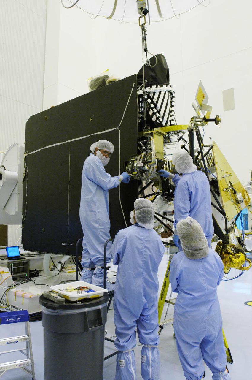 KENNEDY SPACE CENTER, FLA. - In the Payload Hazardous Servicing Facility at NASA’s Kennedy Space Center, engineers finish installing the gimbal on the Mars Reconnaissance Orbiter (MRO) solar panel. A gimbal is an appliance that allows an object to remain horizontal even as its support tips. In the PHSF, the spacecraft will undergo multiple mechanical assembly operations and electrical tests to verify its readiness for launch. A major deployment test will check out the spacecraft’s large solar arrays. The MRO was built by Lockheed Martin for NASA’s Jet Propulsion Laboratory in California. It is the next major step in Mars exploration and scheduled for launch from Cape Canaveral Air Force Station in a window opening Aug. 10. The MRO is an important next step in fulfilling NASA’s vision of space exploration and ultimately sending human explorers to Mars and beyond.