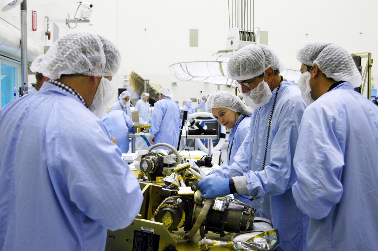 KENNEDY SPACE CENTER, FLA. - In the Payload Hazardous Servicing Facility at NASA’s Kennedy Space Center, engineers prepare a second gimbal for installation on a Mars Reconnaissance Orbiter (MRO) solar panel. A gimbal is an appliance that allows an object to remain horizontal even as its support tips. In the PHSF, the spacecraft will undergo multiple mechanical assembly operations and electrical tests to verify its readiness for launch. A major deployment test will check out the spacecraft’s large solar arrays. The MRO was built by Lockheed Martin for NASA’s Jet Propulsion Laboratory in California. It is the next major step in Mars exploration and scheduled for launch from Cape Canaveral Air Force Station in a window opening Aug. 10. The MRO is an important next step in fulfilling NASA’s vision of space exploration and ultimately sending human explorers to Mars and beyond.
