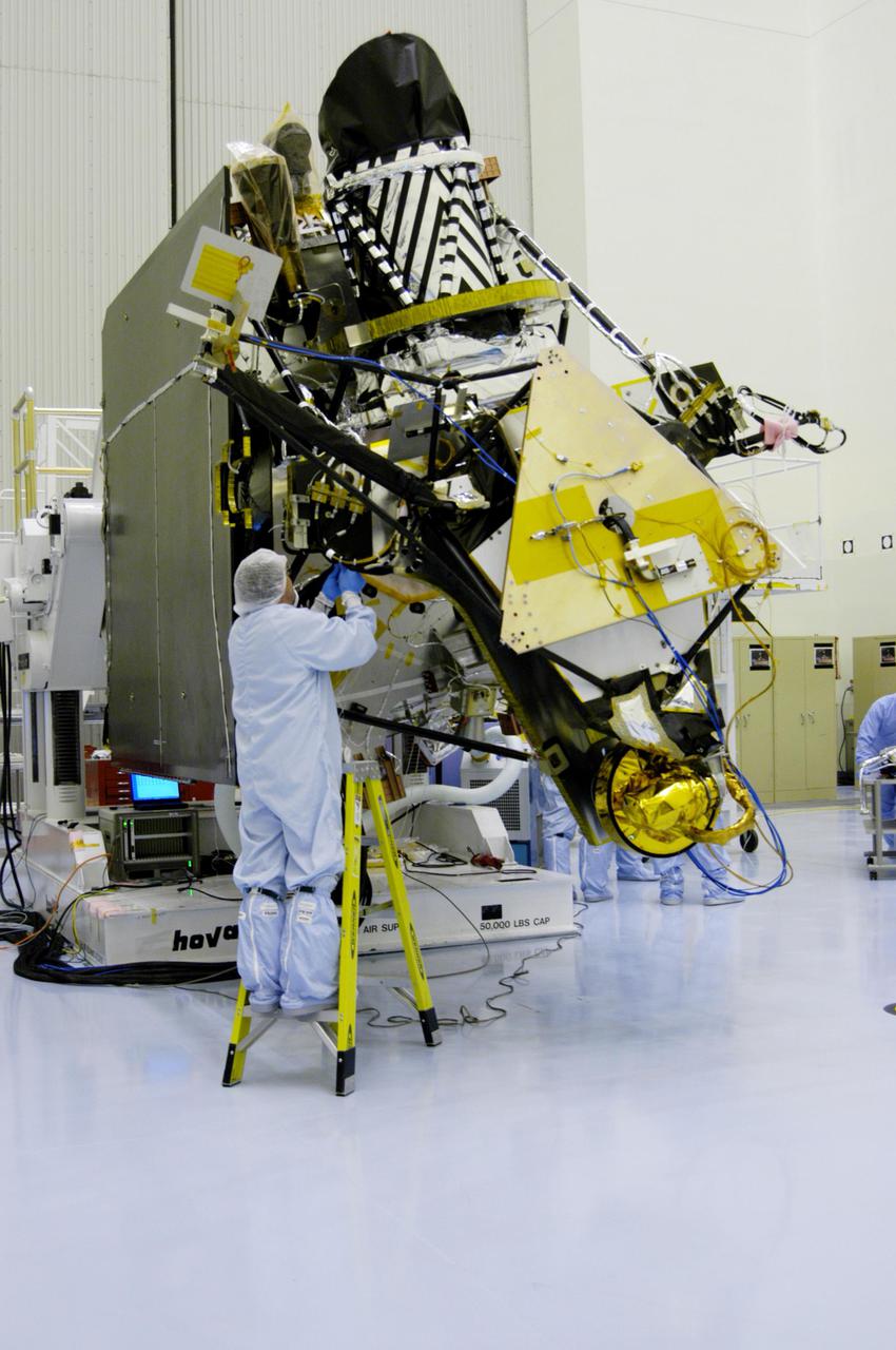 KENNEDY SPACE CENTER, FLA. - In the Payload Hazardous Servicing Facility at NASA’s Kennedy Space Center, an engineer installs a second gimbal on a Mars Reconnaissance Orbiter (MRO) solar panel. A gimbal is an appliance that allows an object to remain horizontal even as its support tips. In the PHSF, the spacecraft will undergo multiple mechanical assembly operations and electrical tests to verify its readiness for launch. A major deployment test will check out the spacecraft’s large solar arrays. The MRO was built by Lockheed Martin for NASA’s Jet Propulsion Laboratory in California. It is the next major step in Mars exploration and scheduled for launch from Cape Canaveral Air Force Station in a window opening Aug. 10. The MRO is an important next step in fulfilling NASA’s vision of space exploration and ultimately sending human explorers to Mars and beyond.