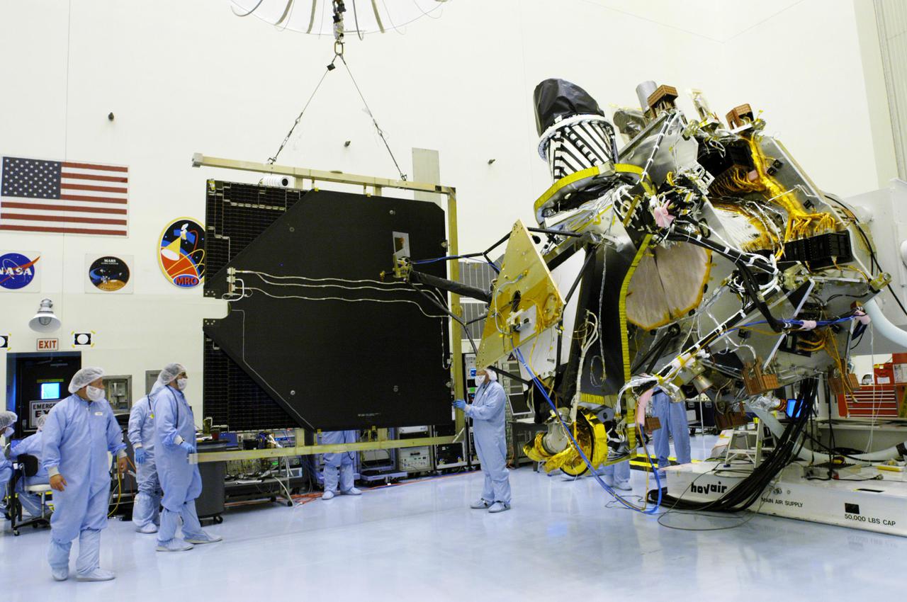 KENNEDY SPACE CENTER, FLA. - In the Payload Hazardous Servicing Facility, workers stabilize the crane holding the solar panel removed from the Mars Reconnaissance Orbiter spacecraft.  A major deployment test will check out the spacecraft’s large solar arrays.  The spacecraft will also undergo multiple mechanical assembly operations and electrical tests to verify its readiness for launch. The MRO was built by Lockheed Martin for NASA’s Jet Propulsion Laboratory in California.  It is the next major step in Mars exploration and scheduled for launch from Cape Canaveral Air Force Station in a window opening Aug. 10. The MRO is an important next step in fulfilling NASA’s vision of space exploration and ultimately sending human explorers to Mars and beyond.