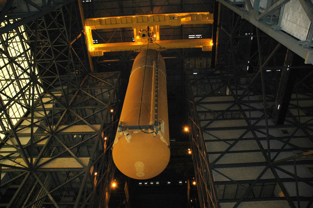 KENNEDY SPACE CENTER, FLA. - An overhead crane lowers the External Tank that will be used to return the Space Shuttle program to flight into high bay 3 in the Vehicle Assembly Building. The tank, ET-121, and the Solid Rocket Boosters were originally scheduled to fly with orbiter Atlantis on mission STS-121 but will now be used to launch Discovery on mission STS-114. Once secure in the high bay, a new heater will be added to the feedline bellows to minimize the potential for ice and frost buildup. STS-114 is the first Return to Flight mission to the International Space Station. The launch window extends from July 13 through July 31.
