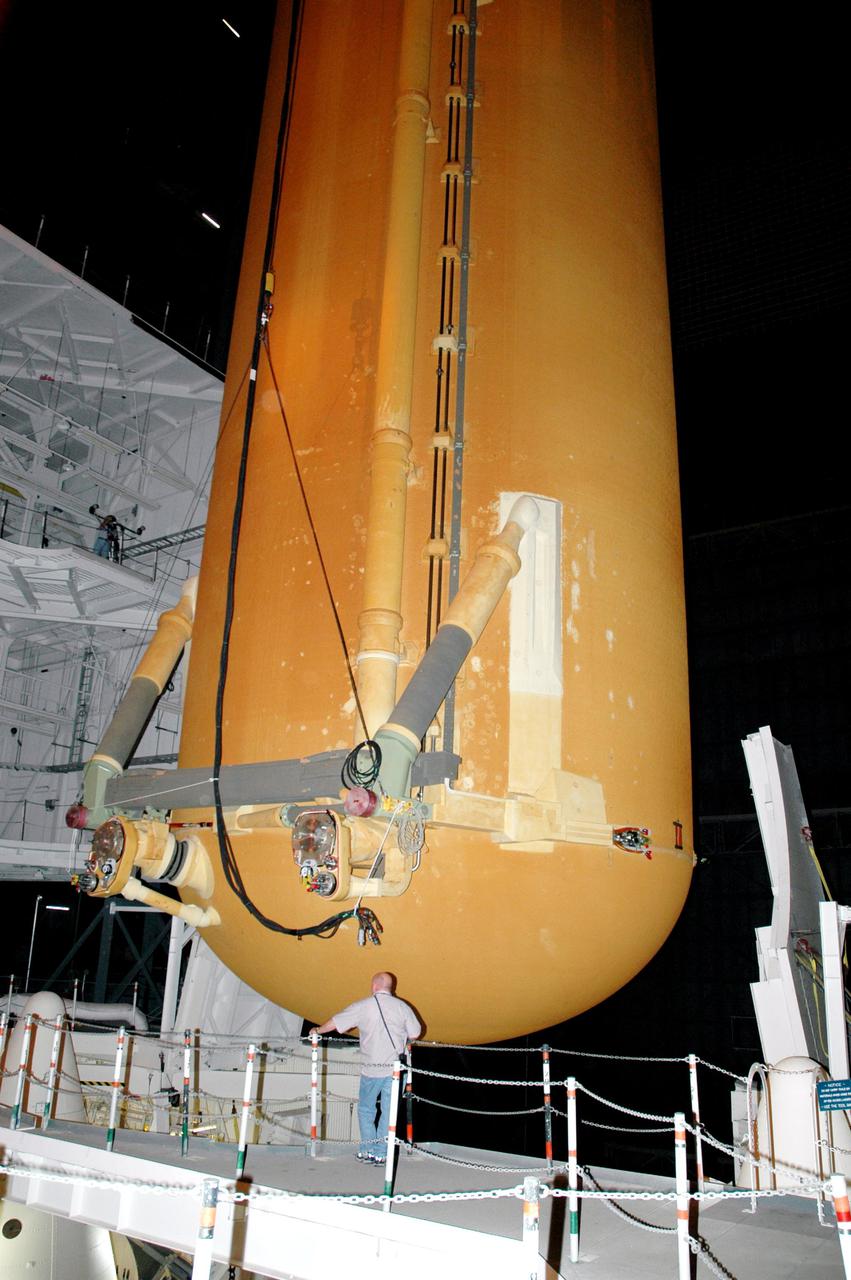 KENNEDY SPACE CENTER, FLA. - A technician monitors the External Tank that will be used to return the Space Shuttle program to flight as it is positioned into high bay 3 in the Vehicle Assembly Building. The tank, ET-121, and the Solid Rocket Boosters were originally scheduled to fly with orbiter Atlantis on mission STS-121 but will now be used to launch Discovery on mission STS-114. Once secure in the high bay, a new heater will be added to the feedline bellows to minimize the potential for ice and frost buildup. STS-114 is the first Return to Flight mission to the International Space Station. The launch window extends from July 13 through July 31.