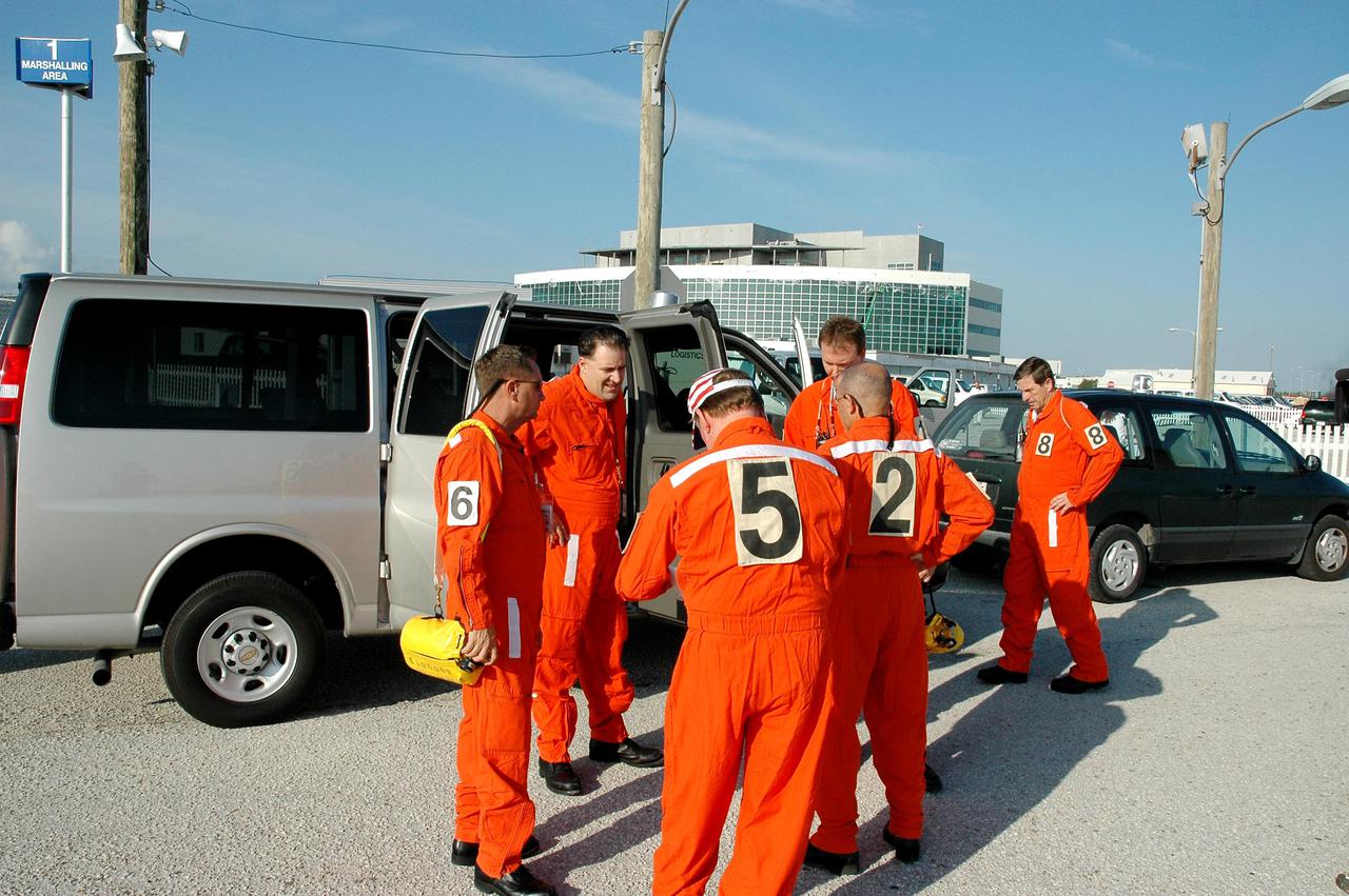 KENNEDY SPACE CENTER, FLA. - Members of the Final Inspection Team check their radios and Emergency Life Support Apparatus (ELSA) equipment before moving to Launch Pad 39B to support an External Tank (ET) tanking test. This team conducts a preflight walkdown of the vehicle and pad during the hold at T-3 hours on launch day. The tanking test is designed to evaluate how the tank, orbiter, solid rocket boosters and ground systems perform under 'cryo-load,' when the tank is filled with the two ultra-low-temperature propellants. The tank filling and draining portion of the test takes about 11 hours. The test also includes a simulated countdown through the hold at T-31 seconds. The test is being conducted to troubleshoot two issues identified by a tanking test held on April 14. Data is being collected to analyze the liquid hydrogen sensors that gave intermittent readings and the liquid hydrogen pressurization relief valve that cycled more times than standard. The tanking tests are part of preparations for Space Shuttle Discovery's Return to Flight mission, STS-114, to the International Space Station. The launch window extends from July 13 through July 31.