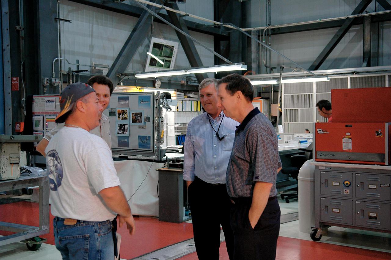KENNEDY SPACE CENTER, FLA. - Michael Griffin, administrator of the National Aeronautics and Space Administration (NASA), talks to United Space Alliance advanced systems technician Richard Van Wart during a tour of Orbiter Processing Facility bay 1. From left are Van Wart, Space Shuttle Atlantis vehicle manager Scott Thurston, Center Director James Kennedy, and Griffin. Space Shuttle Atlantis is being processed for the second Return to Flight mission, STS-121, in the facility. This is Griffin's first official visit to Kennedy Space Center. Griffin is the 11th administrator of NASA, a role he assumed on April 14, 2005. Griffin was nominated to the position in March while serving as the Space Department head at Johns Hopkins University's Applied Physics Laboratory in Baltimore. A registered professional engineer in Maryland and California, Griffin served as chief engineer at NASA earlier in his career. He holds numerous scientific and technical degrees including a Ph.D. in Aerospace Engineering from the University of Maryland.