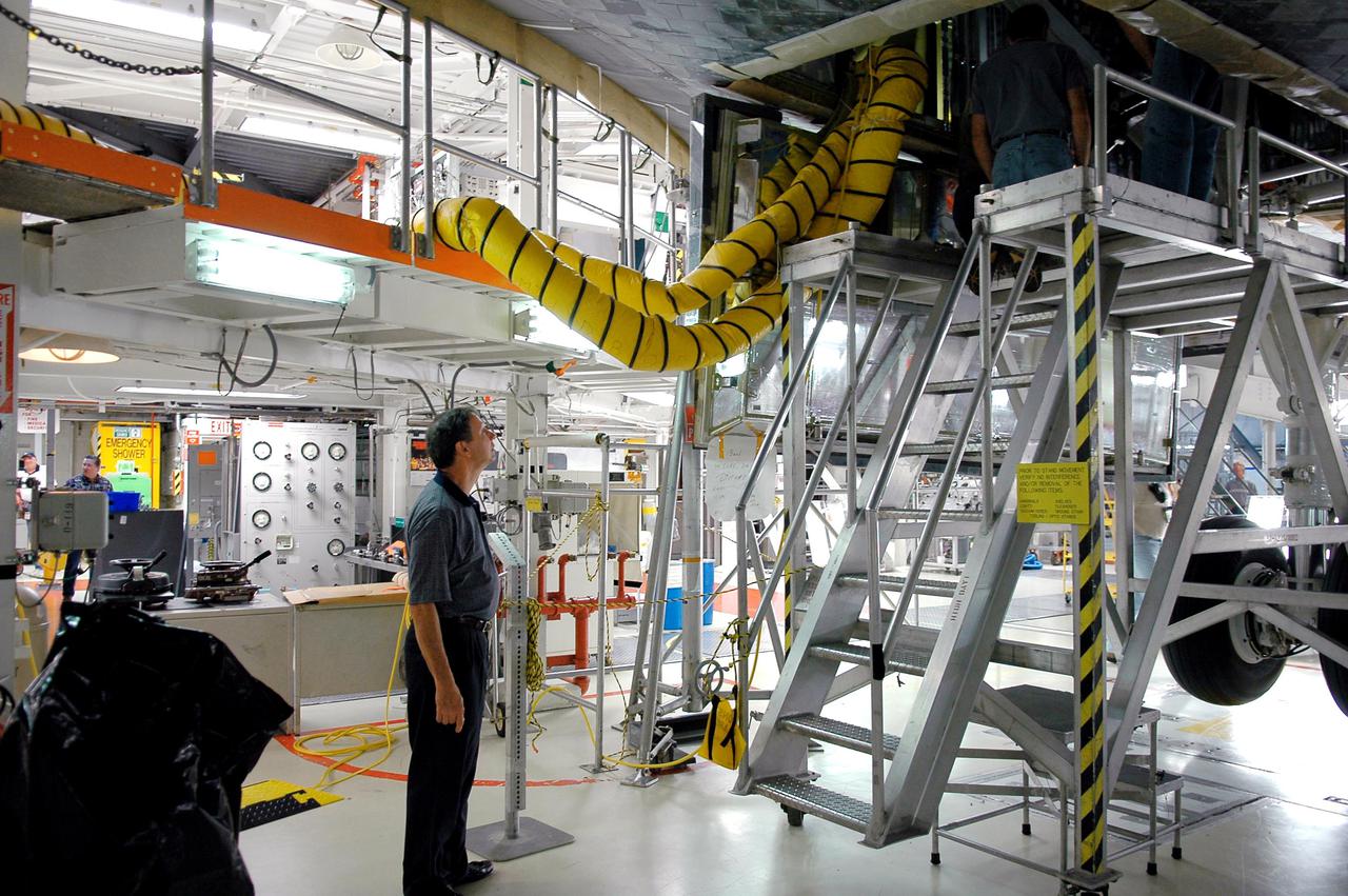 KENNEDY SPACE CENTER, FLA.  -  In Orbiter Processing Facility bay 1, NASA Administrator Michael Griffin observes as technicians prepare Space Shuttle Atlantis for the second Return to Flight mission, STS-121. This is Griffin's first official visit to Kennedy Space Center. Griffin is the 11th administrator of NASA, a role he assumed on April 14, 2005. Griffin was nominated to the position in March while serving as the Space Department head at Johns Hopkins University's Applied Physics Laboratory in Baltimore. A registered professional engineer in Maryland and California, Griffin served as chief engineer at NASA earlier in his career.  He holds numerous scientific and technical degrees including a Ph.D. in Aerospace Engineering from the University of Maryland.