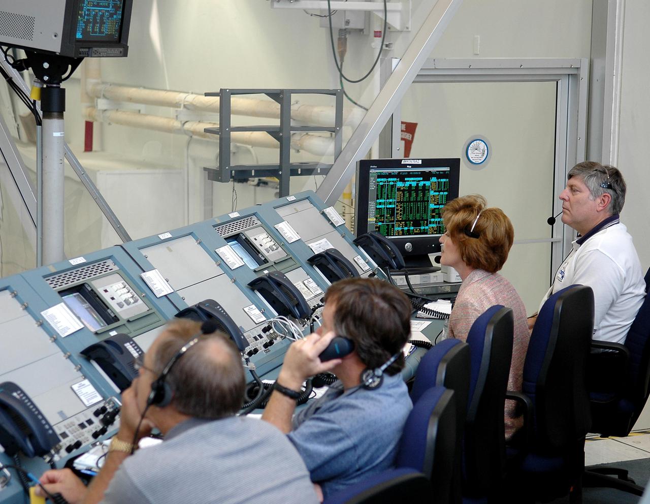 KENNEDY SPACE CENTER, FLA. - Space Shuttle managers support an External Tank (ET) tanking test at Launch Pad 39B from the Launch Control Center. At far right is Ron Wetmore, External Tank Project vice president, Lockheed Martin, and to his left, Sandy Coleman, External Tank Project manager, NASA. The tanking test is designed to evaluate how the tank, orbiter, solid rocket boosters and ground systems perform under 'cryo-load,' when the tank is filled with the two ultra-low-temperature propellants. The tank filling and draining portion of the test takes about 11 hours. The test also includes a simulated countdown through the hold at T-31 seconds. The test is being conducted to troubleshoot two issues identified by a tanking test held on April 14. Data is being collected to analyze the liquid hydrogen sensors that gave intermittent readings and the liquid hydrogen pressurization relief valve that cycled more times than standard. The tanking tests are part of preparations for Space Shuttle Discovery's Return to Flight mission, STS-114, to the International Space Station. The launch window extends from July 13 through July 31.