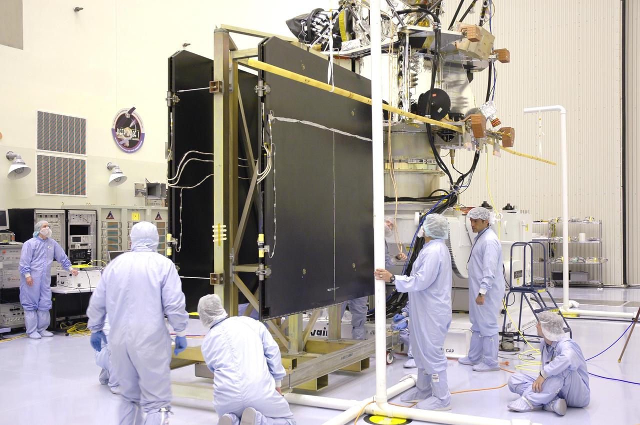 KENNEDY SPACE CENTER, FLA. - In the Payload Hazardous Servicing Facility, technicians prepare the solar arrays for the Mars Reconnaissance Orbiter (MRO) and an antenna simulator (yellow horizontal rod) for an electromagnetic interference verification test.  If no interference is found during the test, the Shallow Radar Antenna (SHARAD) will be installed on the spacecraft. The spacecraft is undergoing multiple mechanical assembly operations and electrical tests to verify its readiness for launch. The MRO was built by Lockheed Martin for NASA’s Jet Propulsion Laboratory in California. It is the next major step in Mars exploration and scheduled for launch from Launch Complex 41 at Cape Canaveral Air Force Station in a window opening Aug. 10. The MRO is an important next step in fulfilling NASA’s vision of space exploration and ultimately sending human explorers to Mars and beyond.