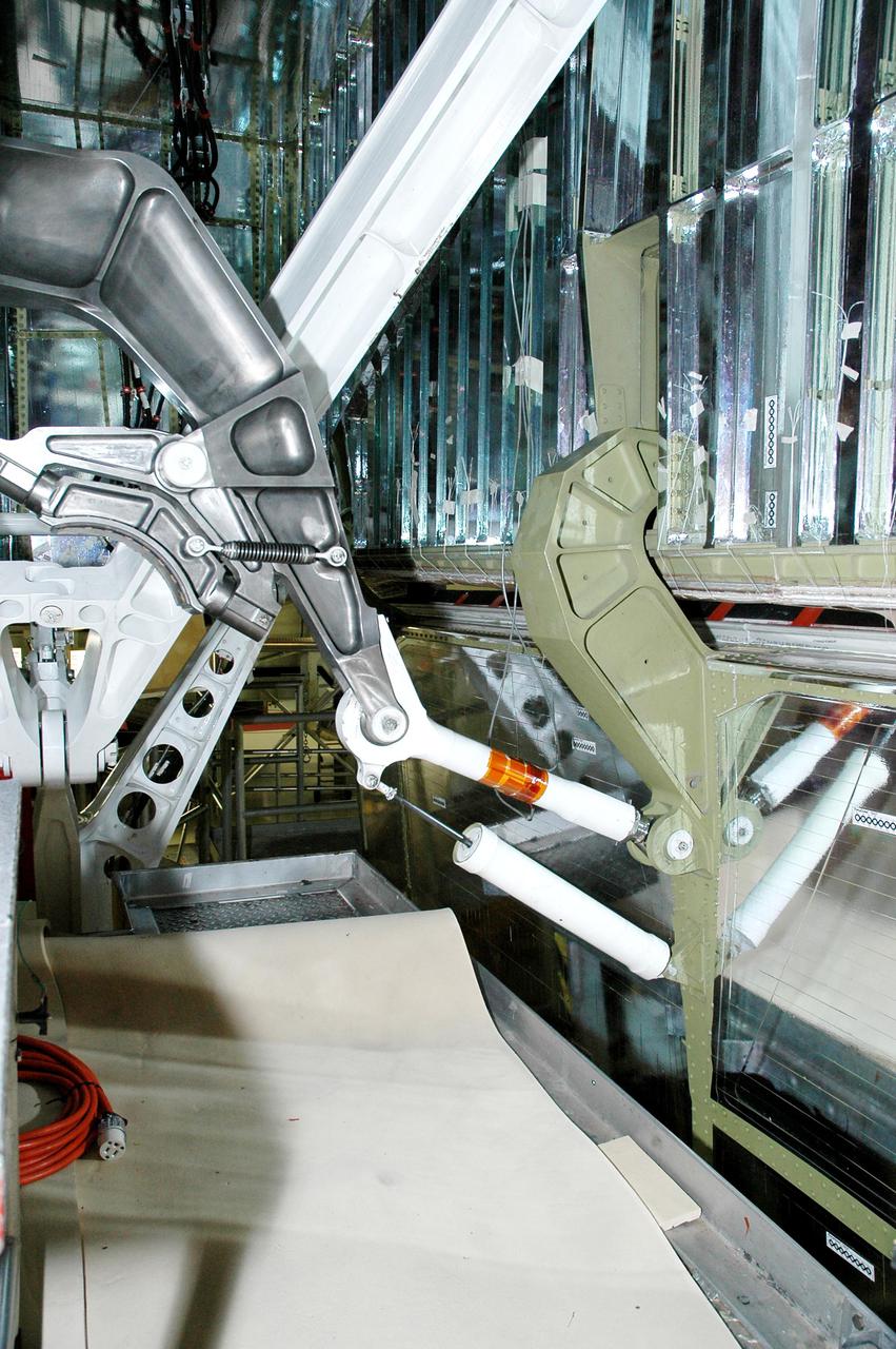 KENNEDY SPACE CENTER, FLA.  -   On Orbiter Atlantis in NASA’s Orbiter Processing Facility, bay 1, a retract link assembly (upper and lower white rods) is on the left-hand main landing gear. Last week a small crack was found on the right-hand assembly.  To lower the main landing gear, a mechanical linkage released by each gear actuates the doors to the open position.  The landing gear reach the full-down and extended position with 10 seconds and are locked in the down position by spring-loaded downlock bungees  Atlantis is scheduled to launch in September 2005 on the second Return to Flight mission, STS-121.