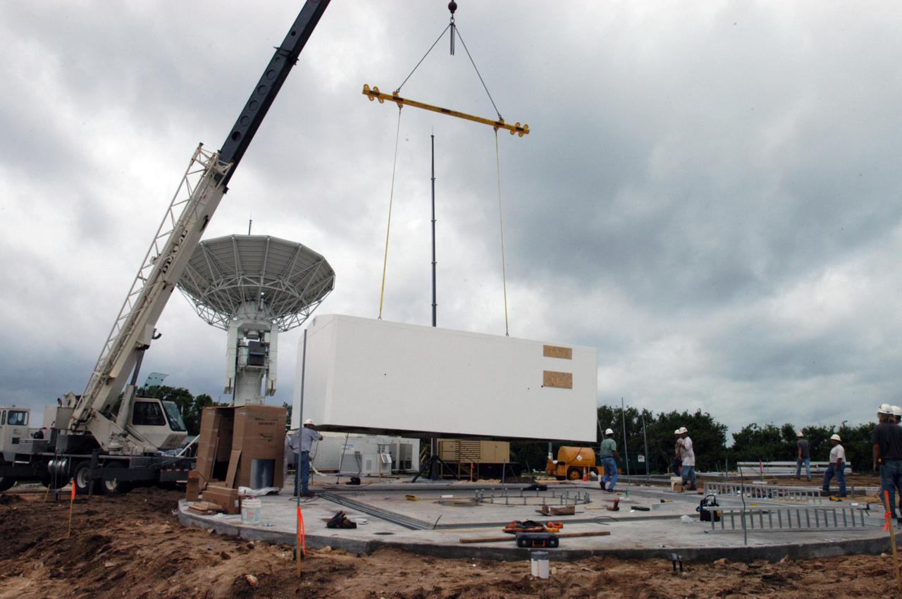 KENNEDY SPACE CENTER, FLA. - Equipment is delivered for installation of another NASA C-band radar at a radar site on North Merritt Island, Fla. The 50-foot C-band radar will be used for long-term Shuttle missions to track the launches and observe possible debris coming from the Shuttle. In the background is an existing 30-foot C-band Pathfinder radar whose use was demonstrated on the Delta Messenger launch. It will be used on the upcoming two Return to Flight missions. The launch window for the first Return to Flight mission, STS-114, is July 13 to July 31.