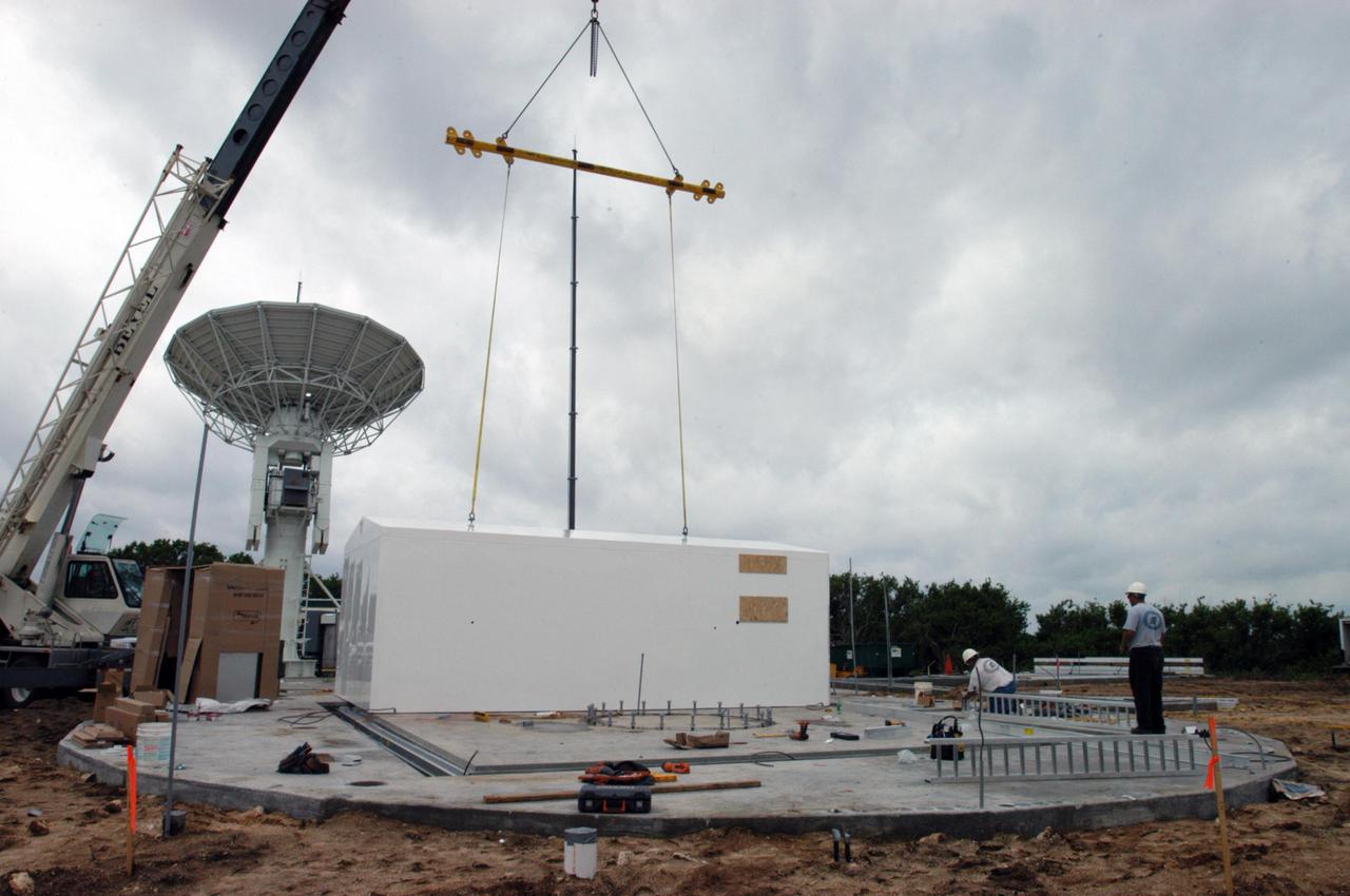 KENNEDY SPACE CENTER, FLA. - Equipment is delivered for installation of another NASA C-band radar at a radar site on North Merritt Island, Fla. The 50-foot C-band radar will be used for long-term Shuttle missions to track the launches and observe possible debris coming from the Shuttle. In the background is an existing 30-foot C-band Pathfinder radar whose use was demonstrated on the Delta Messenger launch. It will be used on the upcoming two Return to Flight missions. The launch window for the first Return to Flight mission, STS-114, is July 13 to July 31.