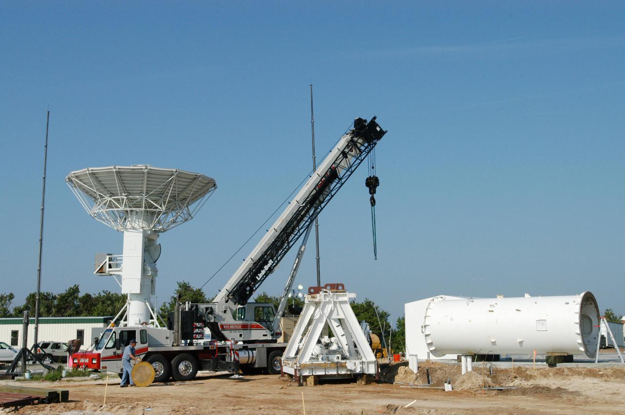 KENNEDY SPACE CENTER, FLA. - Equipment is delivered for installation of another NASA C-band radar at a radar site on North Merritt Island, Fla. The 50-foot C-band radar will be used for long-term Shuttle missions to track the launches and observe possible debris coming from the Shuttle. In the background is an existing 30-foot C-band Pathfinder radar whose use was demonstrated on the Delta Messenger launch. It will be used on the upcoming two Return to Flight missions. The launch window for the first Return to Flight mission, STS-114, is July 13 to July 31.