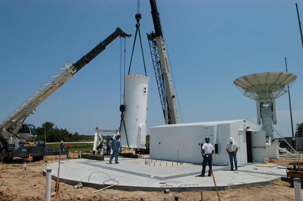 KENNEDY SPACE CENTER, FLA. - Equipment is delivered for installation of another NASA C-band radar at a radar site on North Merritt Island, Fla. The 50-foot C-band radar will be used for long-term Shuttle missions to track the launches and observe possible debris coming from the Shuttle. In the background is an existing 30-foot C-band Pathfinder radar whose use was demonstrated on the Delta Messenger launch. It will be used on the upcoming two Return to Flight missions. The launch window for the first Return to Flight mission, STS-114, is July 13 to July 31.