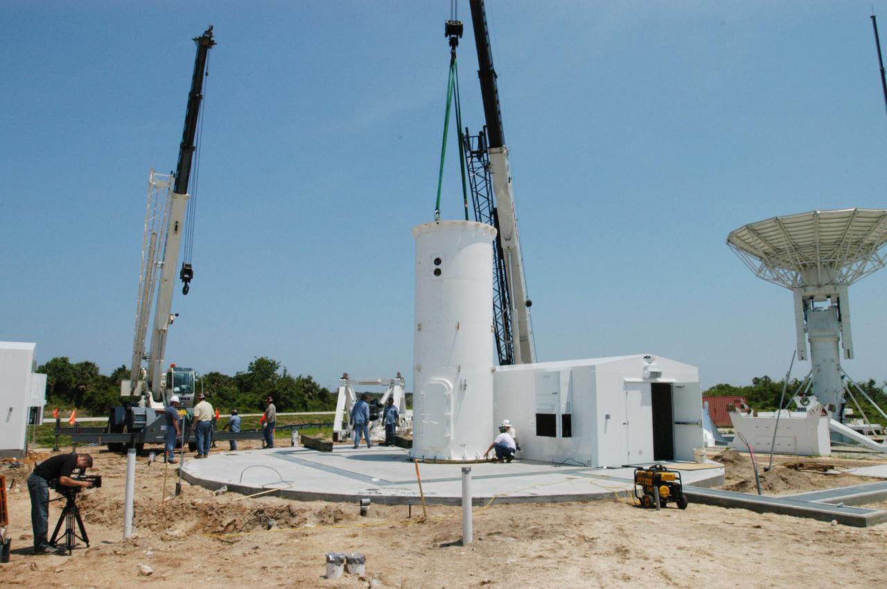 KENNEDY SPACE CENTER, FLA. - Equipment is delivered for installation of another NASA C-band radar at a radar site on North Merritt Island, Fla. The 50-foot C-band radar will be used for long-term Shuttle missions to track the launches and observe possible debris coming from the Shuttle. In the background is an existing 30-foot C-band Pathfinder radar whose use was demonstrated on the Delta Messenger launch. It will be used on the upcoming two Return to Flight missions. The launch window for the first Return to Flight mission, STS-114, is July 13 to July 31.