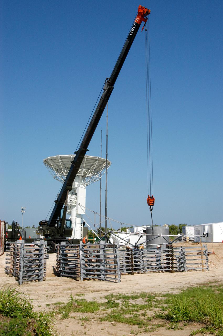 KENNEDY SPACE CENTER, FLA. - At a radar site on North Merritt Island, Fla., north of the Haulover Canal, workers begin assembling the dish for the 50-foot NASA C-band radar. The radar will be used for long-term Shuttle missions to track the launches and observe possible debris coming from the Shuttle. In the background is an existing 30-foot C-band Pathfinder radar whose use was demonstrated on the Delta Messenger launch. It will be used on the upcoming two Return to Flight missions. The launch window for the first Return to Flight mission, STS-114, is July 13 to July 31.