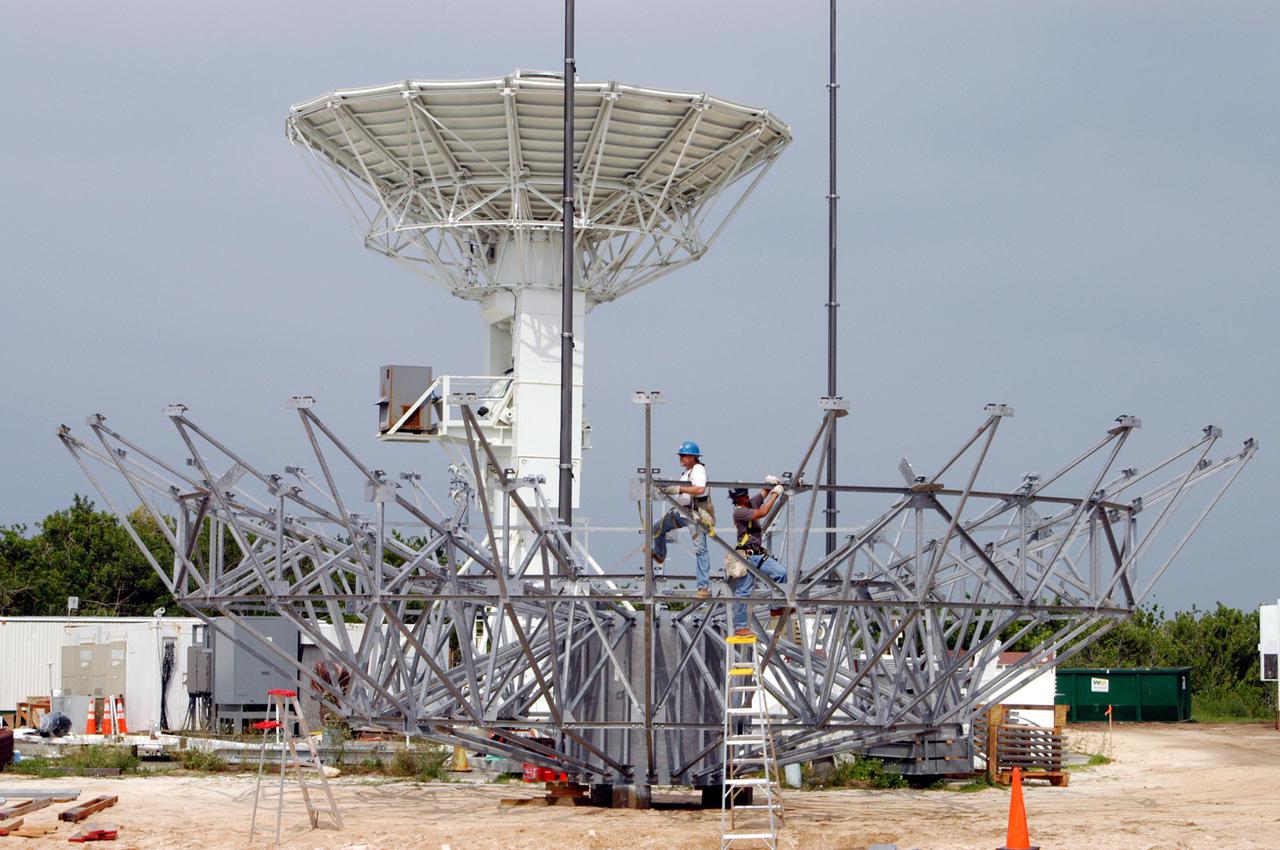 KENNEDY SPACE CENTER, FLA. - At a radar site on North Merritt Island, Fla., north of the Haulover Canal, workers continue assembling a 50-foot C-band radar. The radar will be used for long-term Shuttle missions to track the launches and observe possible debris coming from the Shuttle. In the background is an existing 30-foot C-band Pathfinder radar whose use was demonstrated on the Delta Messenger launch. It will be used on the upcoming two Return to Flight missions. The launch window for the first Return to Flight mission, STS-114, is July 13 to July 31.