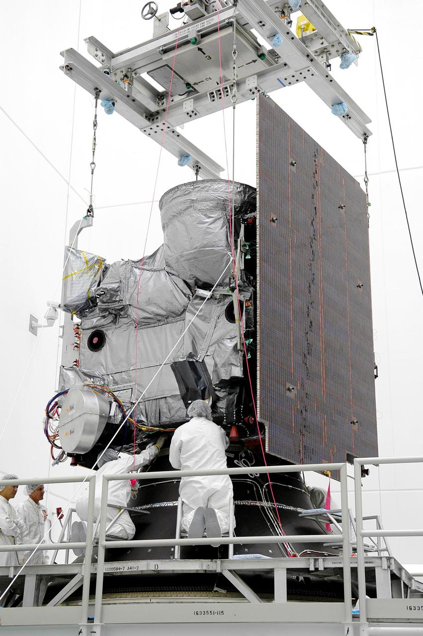KENNEDY SPACE CENTER, FLA. - At Astrotech Space Operations in Titusville, Fla., Boeing workers attach the Geostationary Operational Environmental Satellite GOES-N to the Payload Attach Fitting. The fitting will enable the spacecraft to be mated to its launch vehicle, a Boeing Delta IV, with a 3-burn second-stage operation. Since its arrival on March 11, the satellite has been undergoing final testing by Boeing Satellite Systems of the imaging system, instrumentation, communications and power systems. The GOES spacecraft are sponsored by NASA’s Goddard Space Flight Center and the National Oceanic and Atmospheric Administration. GOES-N is targeted to launch June 23 from Launch Complex 37 at Cape Canaveral Air Force Station in Florida.