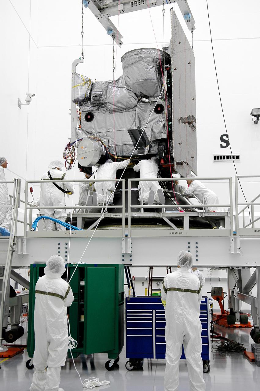 KENNEDY SPACE CENTER, FLA. - At Astrotech Space Operations in Titusville, Fla., Boeing workers attach the Geostationary Operational Environmental Satellite GOES-N to the Payload Attach Fitting. The fitting will enable the spacecraft to be mated to its launch vehicle, a Boeing Delta IV, with a 3-burn second-stage operation. Since its arrival on March 11, the satellite has been undergoing final testing by Boeing Satellite Systems of the imaging system, instrumentation, communications and power systems. The GOES spacecraft are sponsored by NASA’s Goddard Space Flight Center and the National Oceanic and Atmospheric Administration. GOES-N is targeted to launch June 23 from Launch Complex 37 at Cape Canaveral Air Force Station in Florida.