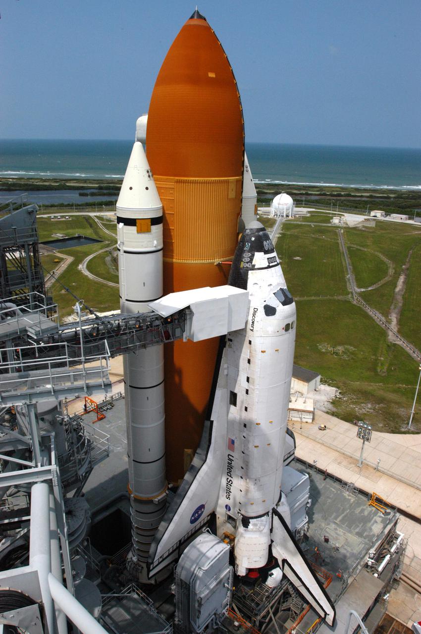 KENNEDY SPACE CENTER, FLA.  -   On Launch Pad 39B, Space Shuttle Discovery is revealed after rollback of the Rotating Service Structure.  The Orbiter Access Arm can be seen extended to the cockpit.  Discovery will be rolled back to the Vehicle Assembly Building.  Once inside the VAB, Discovery will be demated from its External Tank and lifted into the transfer aisle.  On or about June 7, Discovery will be lifted and attached to its new tank and Solid Rocket Boosters, which are already in the VAB.  Only the 15th rollback in Space Shuttle Program history, the 4.2-mile journey allows additional modifications to be made to the External Tank prior to a safe Return to Flight.  Discovery is expected to be rolled back to the launch pad in mid-June for Return to Flight mission STS-114.  The launch window extends from July 13 to July 31.