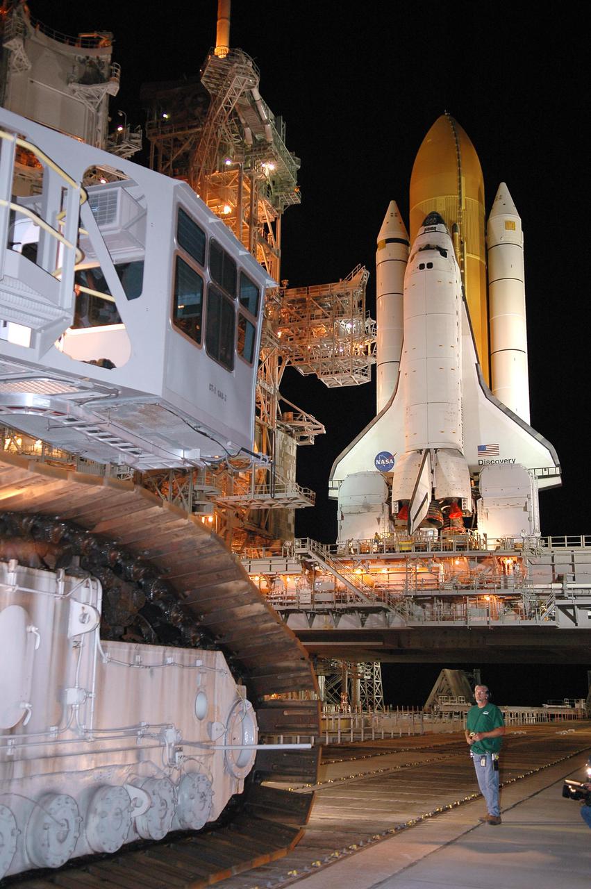 KENNEDY SPACE CENTER, FLA. - In the early morning hours, the Crawler_Transporter, at left, inches its way toward Space Shuttle Discovery and the Mobile Launcher Platform, at right. The Shuttle is being rolled back to the Vehicle Assembly Building. Once inside the VAB, Discovery will be demated from its External Tank and lifted into the transfer aisle. On or about June 7, Discovery will be lifted and attached to its new tank and Solid Rocket Boosters, which are already in the VAB. Only the 15th rollback in Space Shuttle Program history, the 4.2-mile journey allows additional modifications to be made to the External Tank prior to a safe Return to Flight. Discovery is expected to be rolled back to the launch pad in mid-June for Return to Flight mission STS-114. The launch window extends from July 13 to July 31.