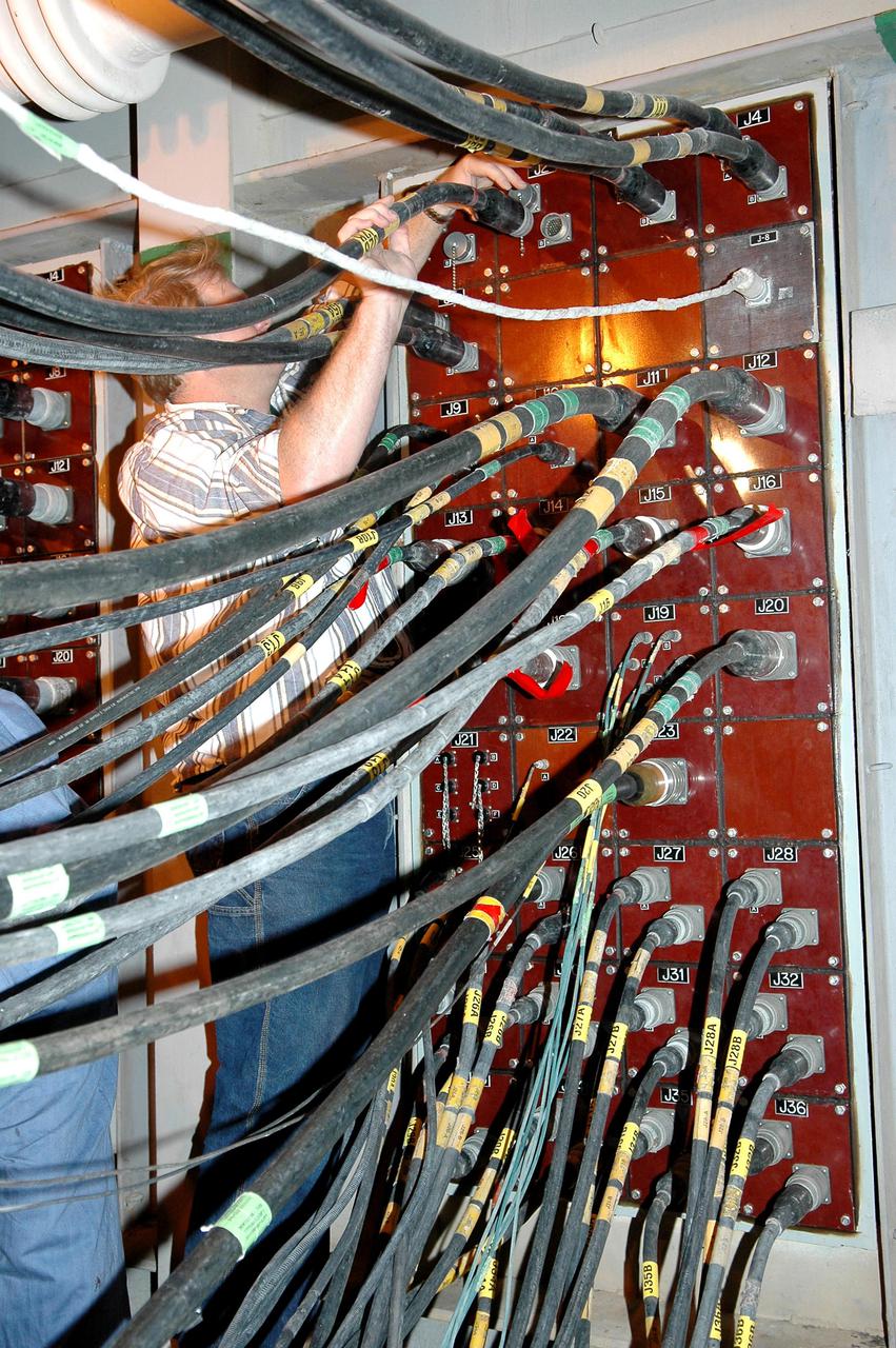 KENNEDY SPACE CENTER, FLA. - On Launch Pad 39B, workers demate the fittings between the Mobile Launcher Platform (MLP) and the pad to allow the MLP with Space Shuttle Discovery to return to the Vehicle Assembly Building. The fittings provide ground electrical power and connections for vehicle data and communications. Once inside the VAB, Discovery will be demated from its External Tank and lifted into the transfer aisle. On or about June 7, Discovery will be lifted and attached to its new tank and Solid Rocket Boosters, which are already in the VAB. Only the 15th rollback in Space Shuttle Program history, the 4.2-mile journey allows additional modifications to be made to the External Tank prior to a safe Return to Flight. Discovery is expected to be rolled back to the launch pad in mid-June for Return to Flight mission STS-114. The launch window extends from July 13 to July 31.
