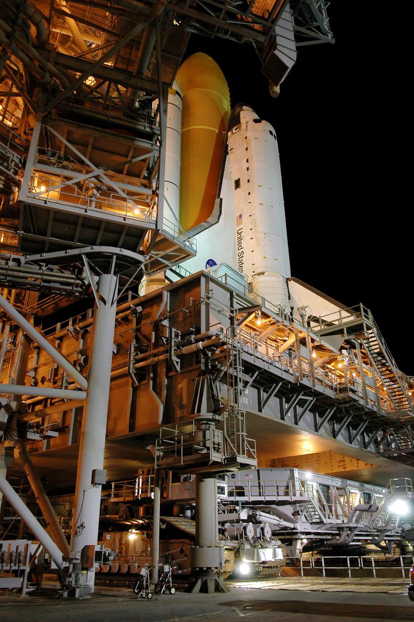 KENNEDY SPACE CENTER, FLA. - In the early morning hours, the Crawler_Transporter is in place under Space Shuttle Discovery and the Mobile Launcher Platform, above. The framework next to the Shuttle is the Fixed Service Structure. The Shuttle is being rolled back to the Vehicle Assembly Building. Once inside the VAB, Discovery will be demated from its External Tank and lifted into the transfer aisle. On or about June 7, Discovery will be lifted and attached to its new tank and Solid Rocket Boosters, which are already in the VAB. Only the 15th rollback in Space Shuttle Program history, the 4.2-mile journey allows additional modifications to be made to the External Tank prior to a safe Return to Flight. Discovery is expected to be rolled back to the launch pad in mid-June for Return to Flight mission STS-114. The launch window extends from July 13 to July 31.
